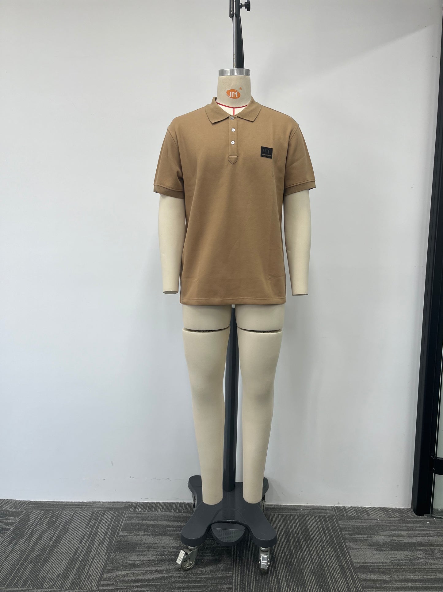 Polo shirt features a classic brown color and a genuine leather label