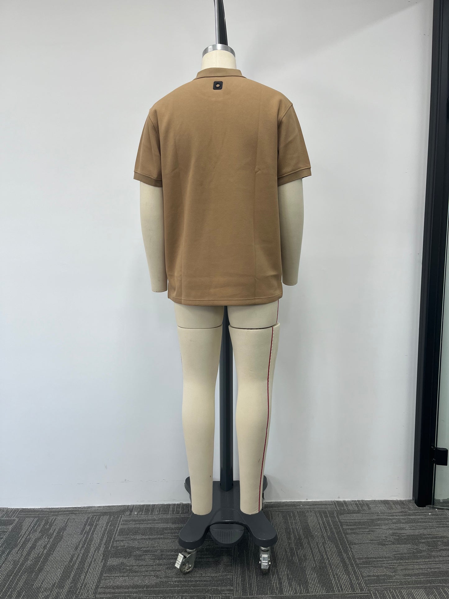 Polo shirt features a classic brown color and a genuine leather label