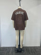 brown polo shirt features a metallic letter print on the back