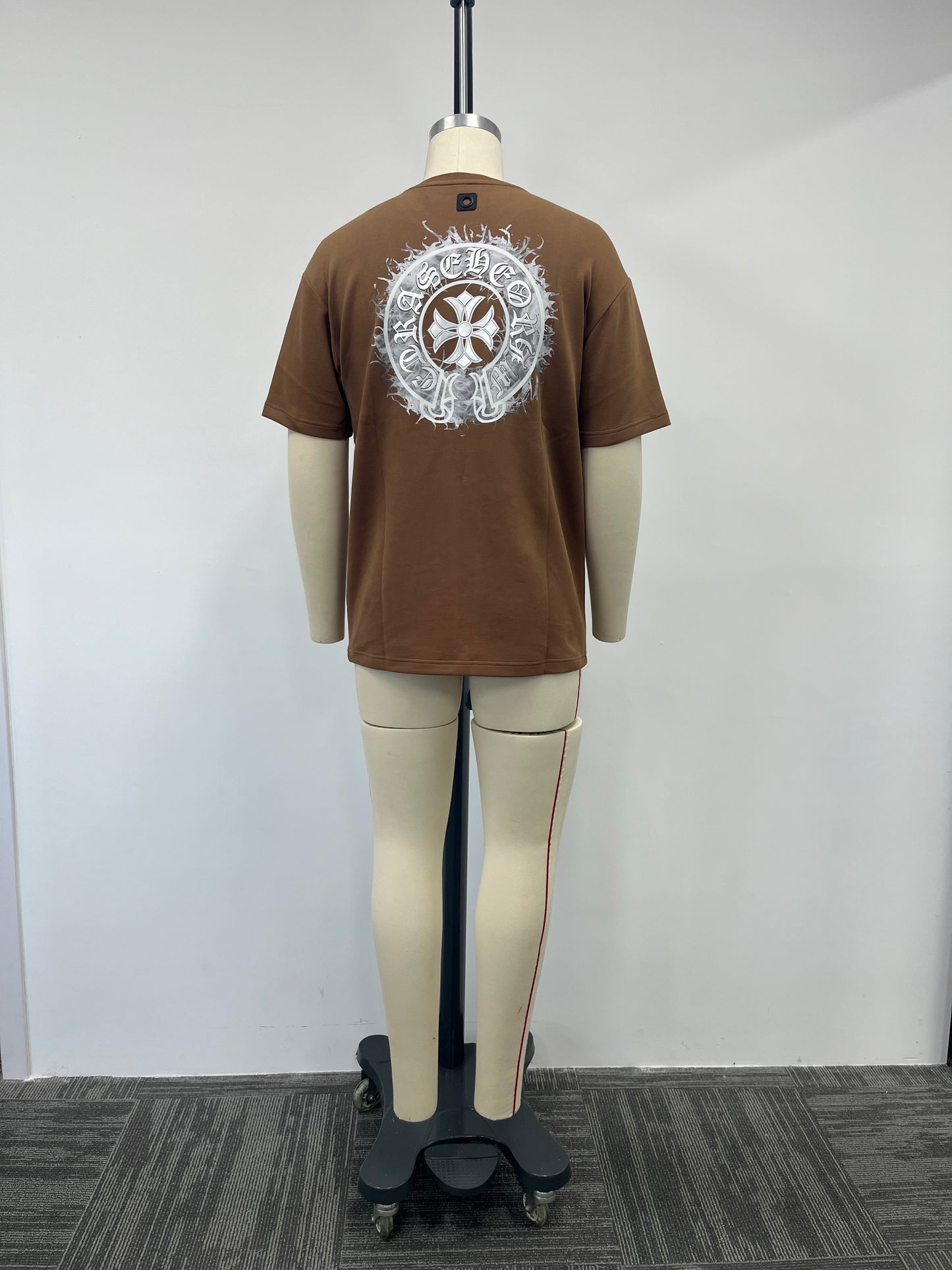 Brown t-shirt features a silver print