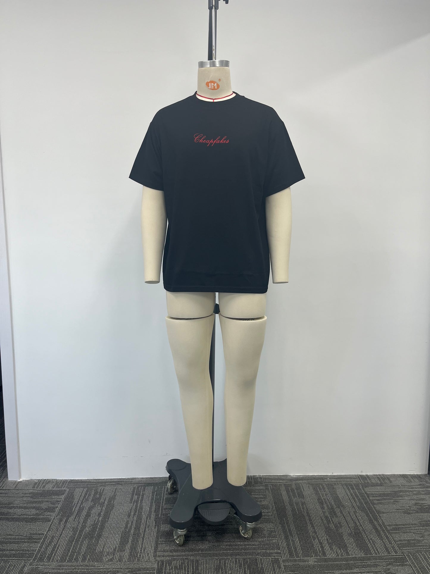 Black T-shirt features a large embroidered patch on the back