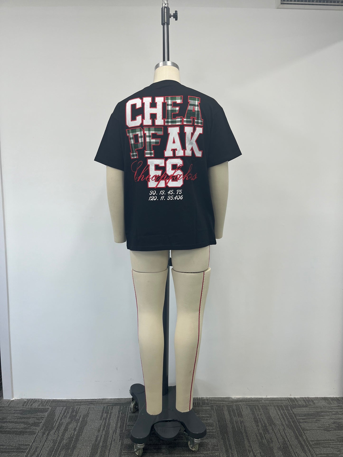 Black T-shirt features a large embroidered patch on the back
