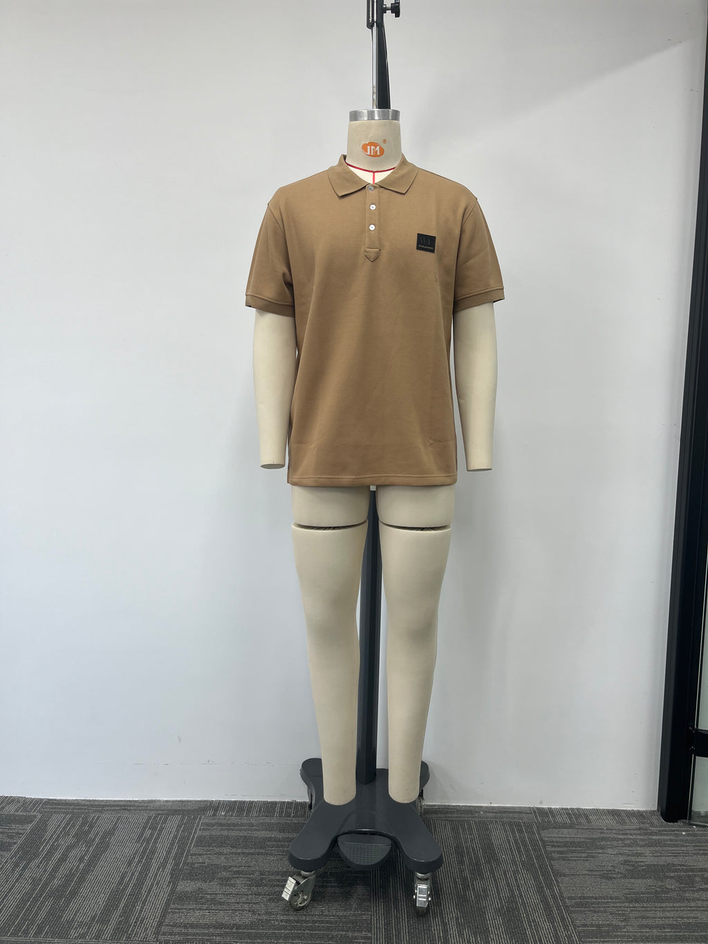 Polo shirt features a classic brown color and a genuine leather label